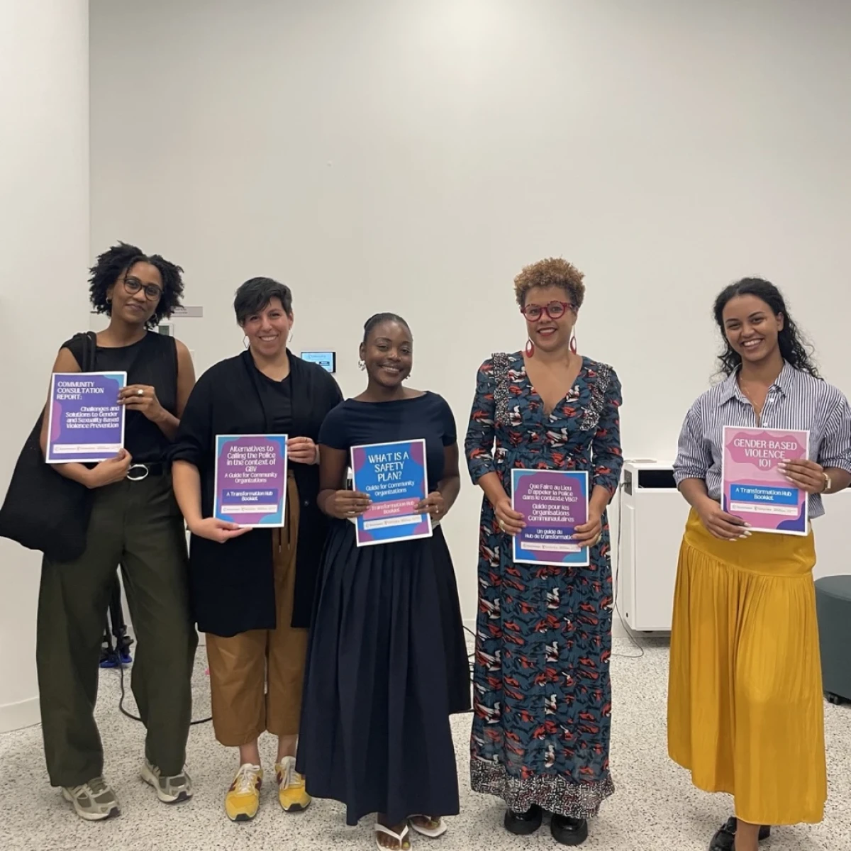 Dalia Elsayed, Natalie Kouri-Towe, Stéphanie Germain, Marlihan Lopez, and Evelyne Marchal Ferrière standing holding copies of the Transformation Hub toolkit.